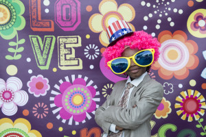 wedding photo booth un bambino con parrucca rosa, occhiali giganti e cappello a stelle e strisce
